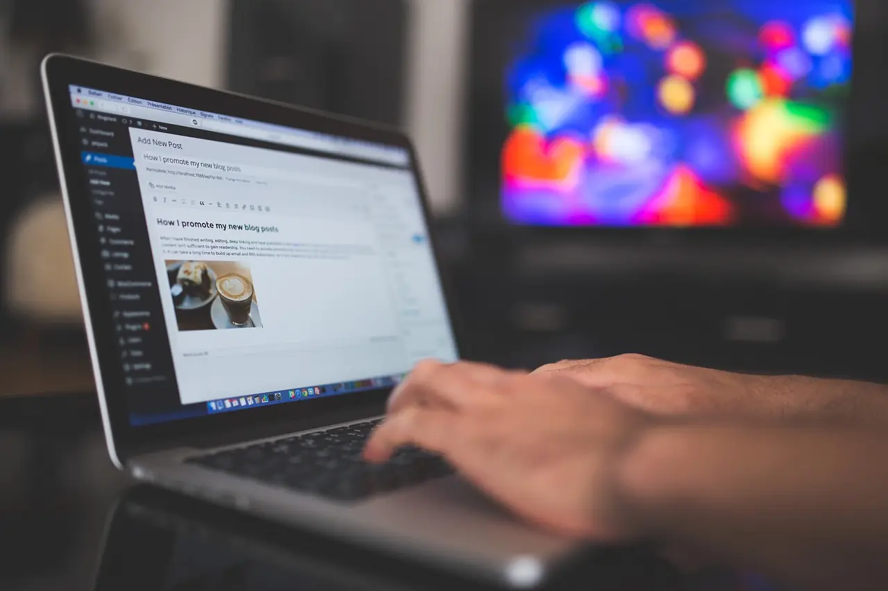 Hands typing on a laptop showing the WordPress dashboard